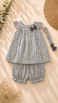 A baby girl's two-piece outfit set featuring a sleeveless top with flutter sleeves and matching bloomers, both in a black and white floral print. The set includes a small black bow on the top and a matching headband.